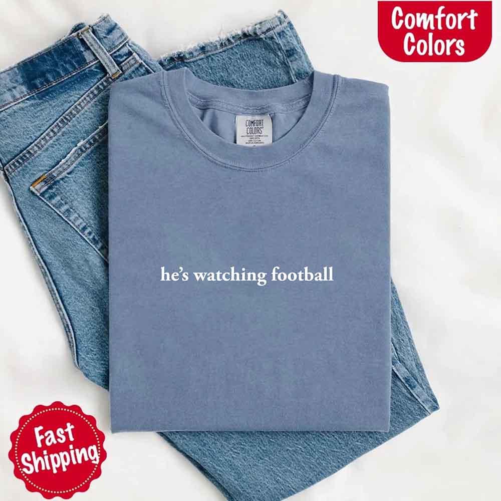 He’s Watching Football Tee - Comfort Colors Funny Shirt for Her