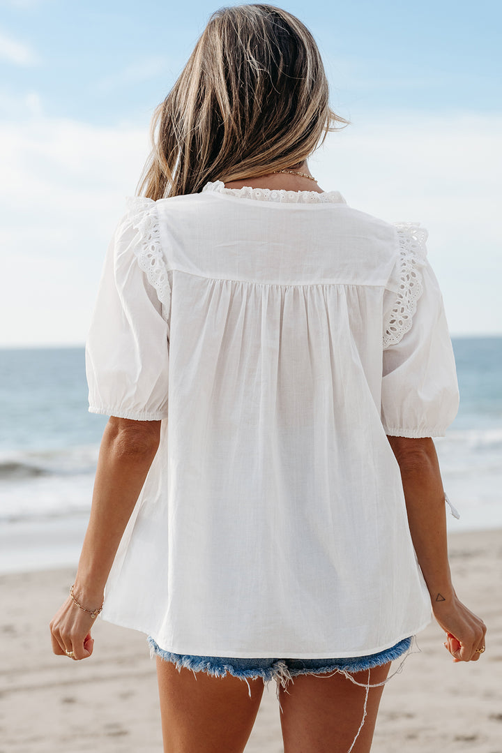 Chemisier blanc à manches courtes bouffantes et col noué en dentelle brodée